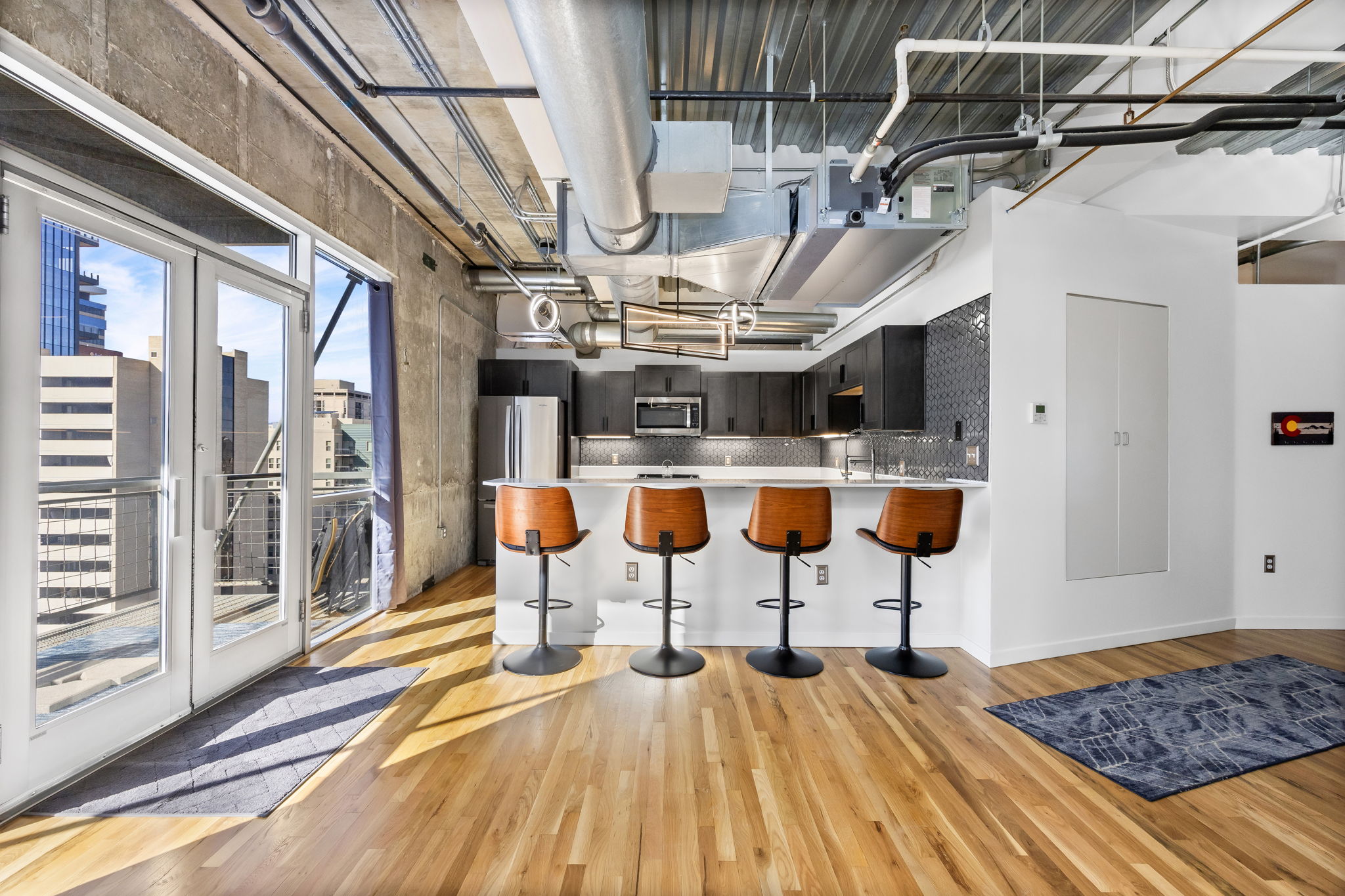 This fully furnished 1 bedroom, 1.5 bathroom condo is located in the sought-after Arapahoe SkyLofts, right in the heart of Denver. Offering 1,124 square feet of thoughtfully designed living space, this home blends modern loft-style character with comfort and convenience.
 
The condo features hardwood floors, concrete walls, and exposed ductwork, creating a clean, contemporary industrial aesthetic. The open living area flows seamlessly into the dining space, which includes seating for four, plus two bar stools at the kitchen counter, making it ideal for entertaining or casual meals.
 
The spacious primary bedroom is furnished with a king bed and provides a quiet retreat. The primary bathroom includes a tub/shower combination, while a convenient half-bath powder room is located off the main living area—perfect for guests. An in-unit washer and dryer adds everyday convenience.
 
Step out onto the private balcony and enjoy views of downtown Denver, a perfect spot for morning coffee or evening relaxation.
 
Parking is a rare downtown luxury, and this unit includes two parking spaces in the attached garage—one suitable for a compact vehicle and the other for a full-size car.
 
Built in 1983, Arapahoe SkyLofts is ideally situated near Union Station and Coors Field, with easy access to downtown office buildings, public transportation, and major roadways. The neighborhood offers an abundance of restaurants, coffee shops, and retail options, all within close proximity.
 
This fully furnished condo provides an exceptional opportunity to enjoy urban living with space, style, and convenience in one of Denver’s most vibrant locations.